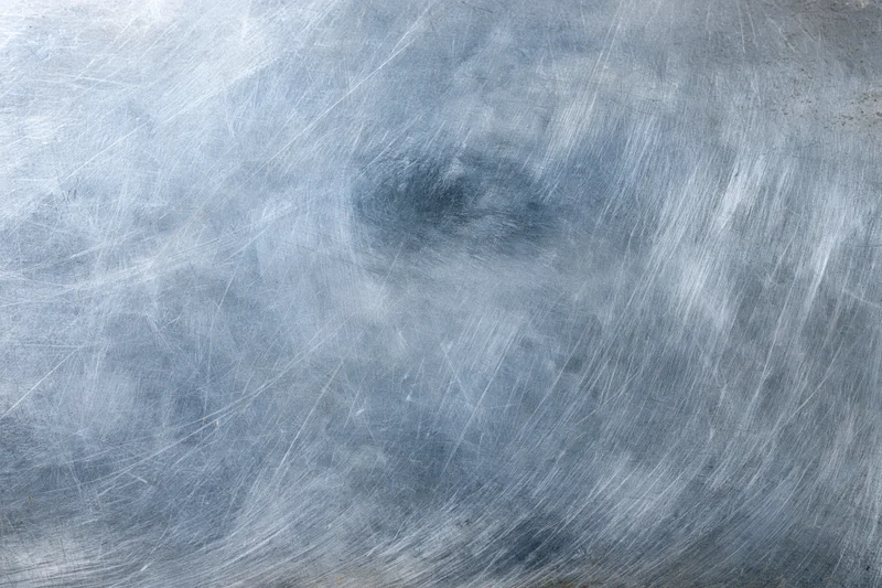Worn metal surface covered in fine scratches and scuffs