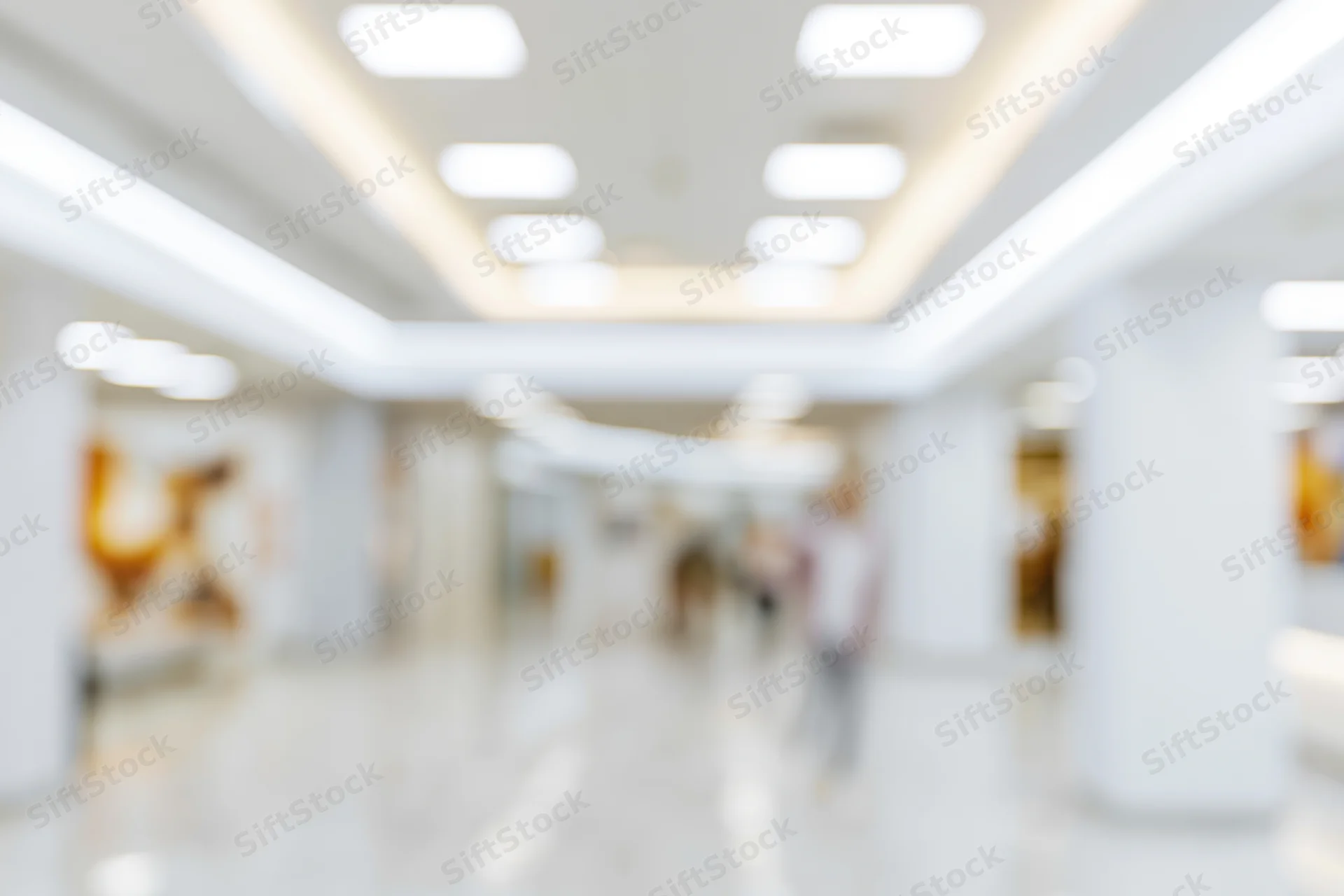 Blurred interior of a bright modern office or retail space with people walking along a hallway