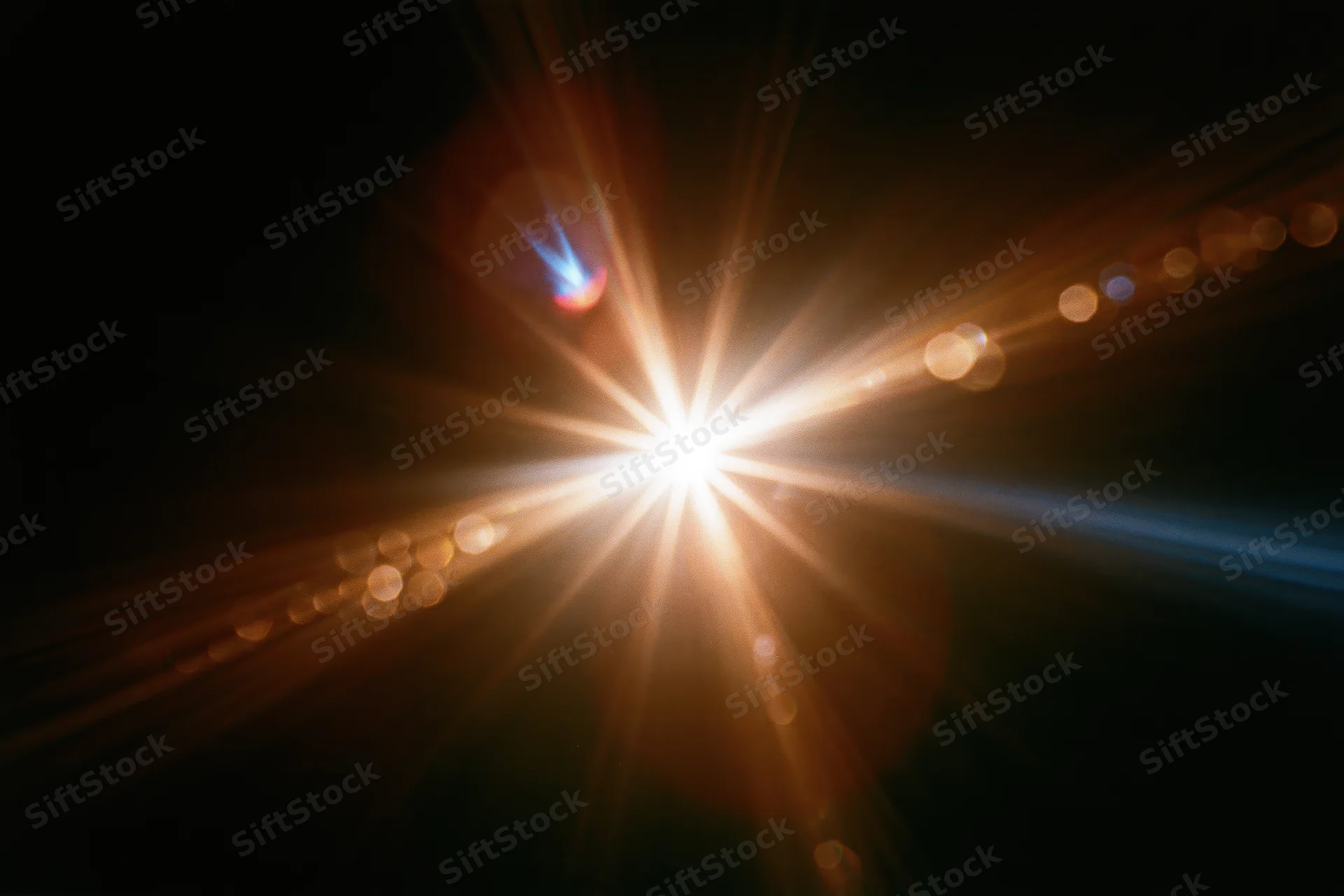 Intense lens flare burst from a single bright point light source in dark background with radiating beams and bokeh circles