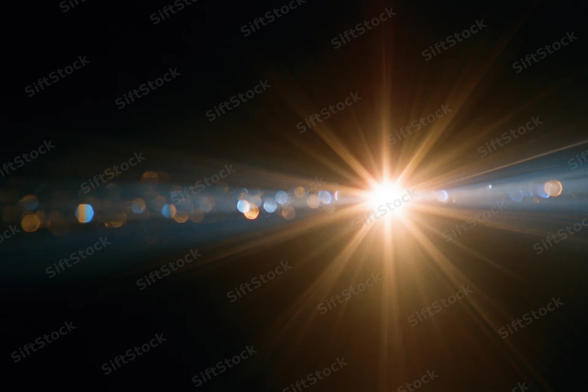 Intense lens flare from a bright point light source radiating rays across a dark background with bokeh lights