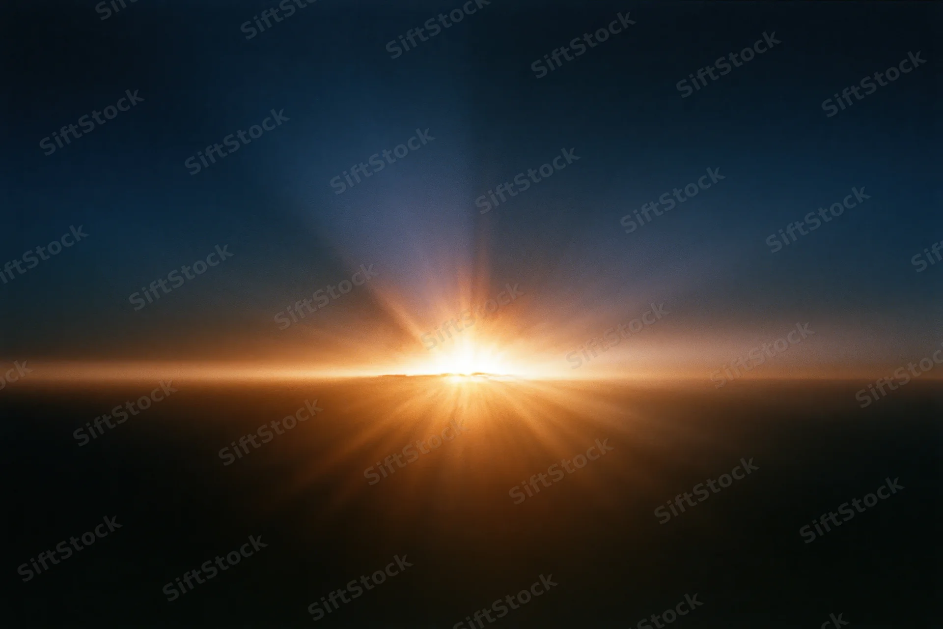 Intense light burst rising from the horizon radiating long sun rays across the sky at dawn