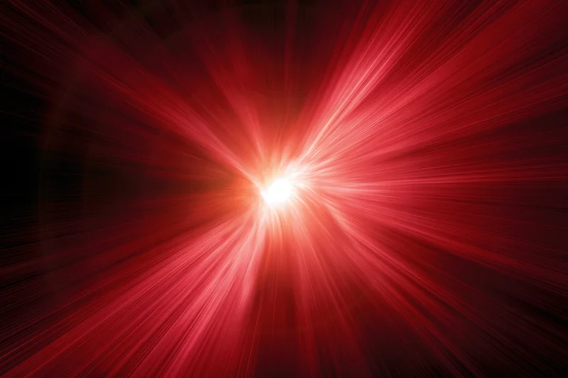 Intense red light burst radiating outward from a bright center