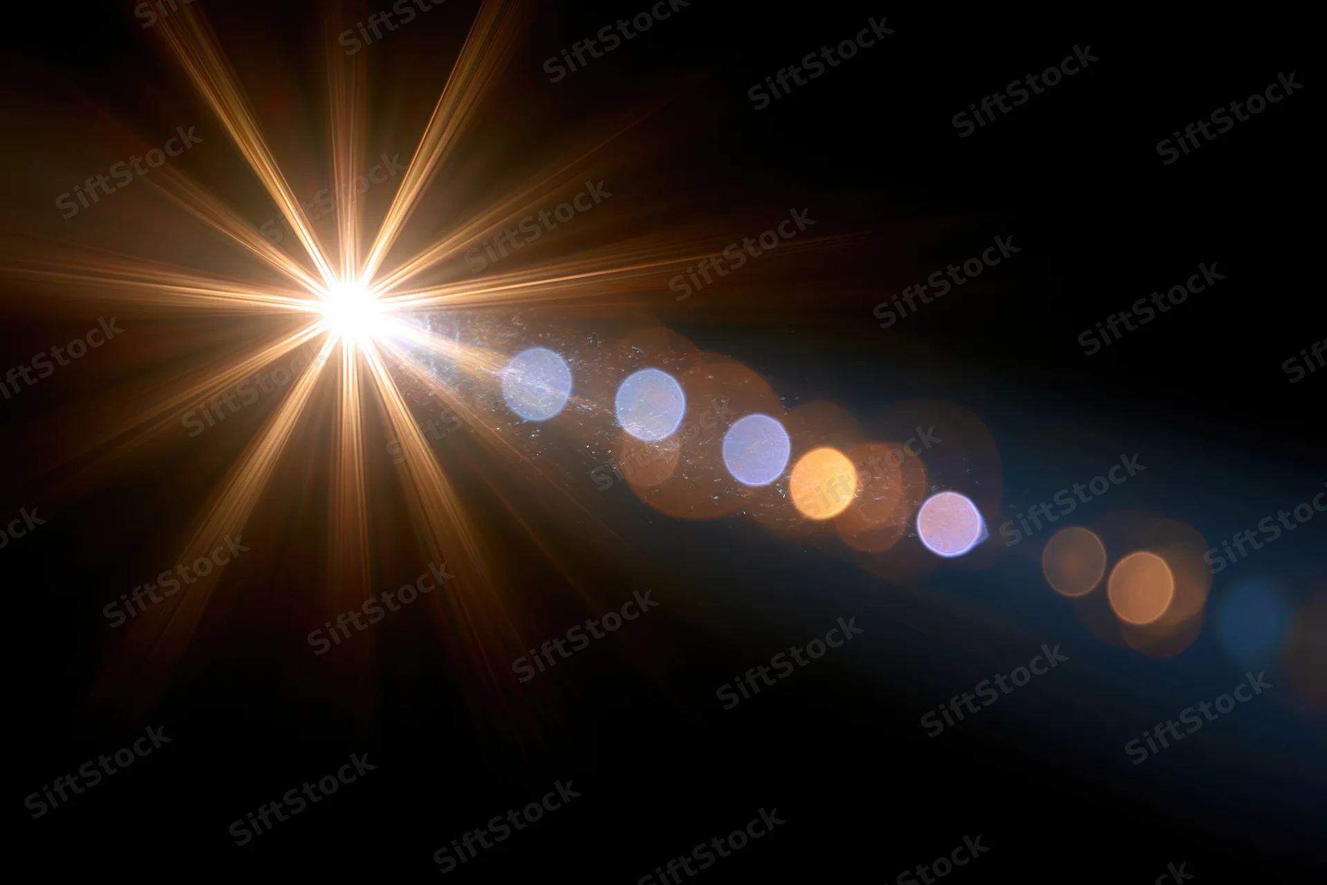 Intense point light source emitting starburst rays with bokeh circles against dark background