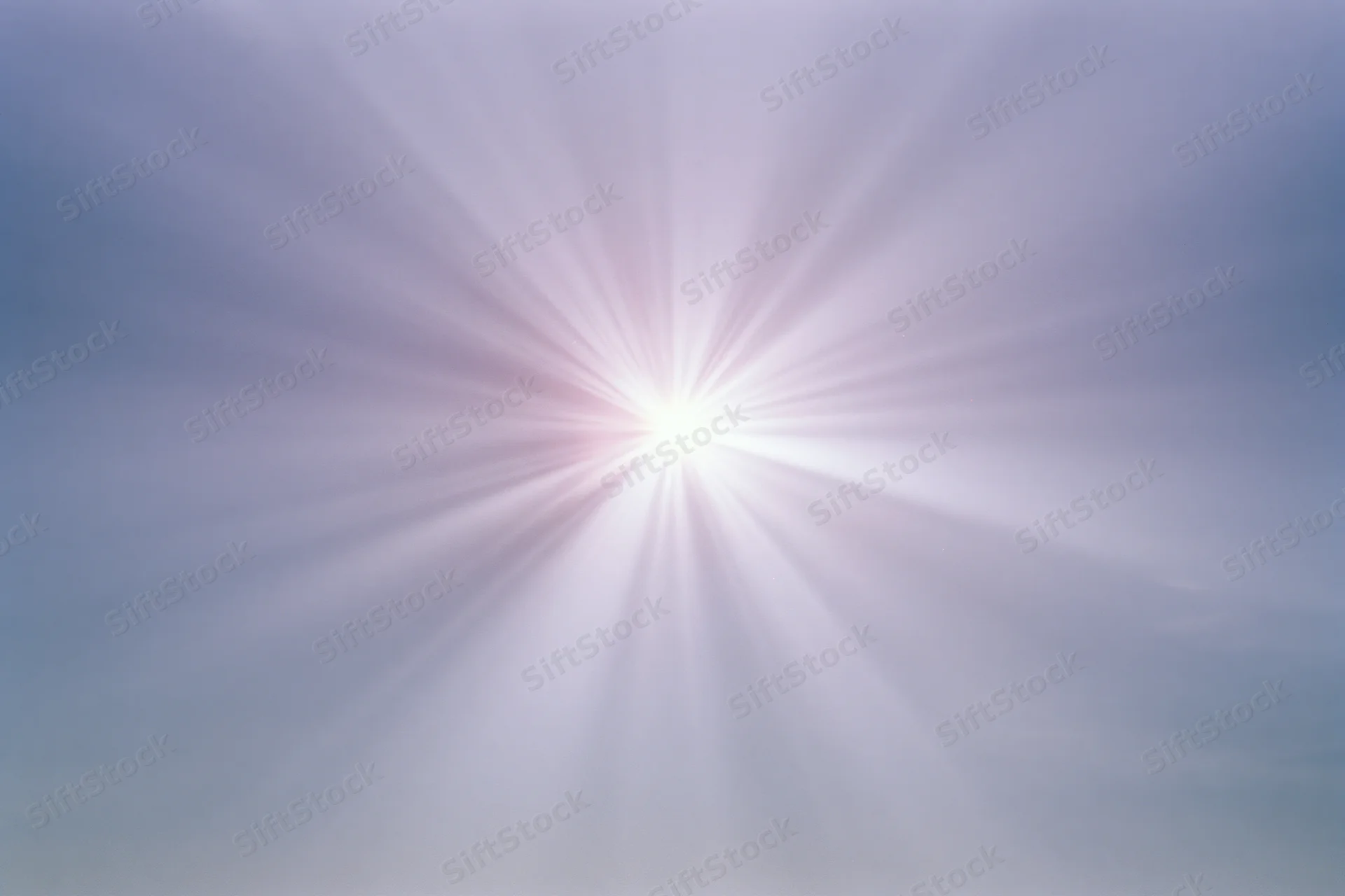 Intense sun flare bursting from center of sky with radiating light beams