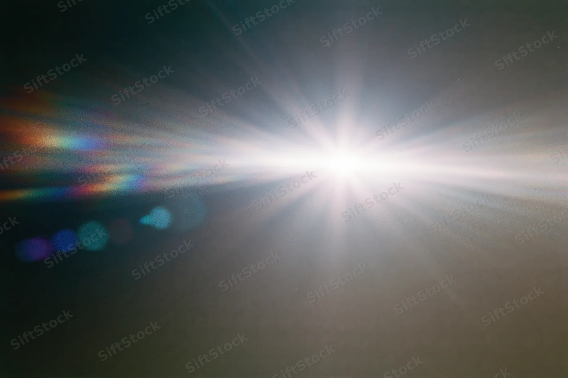 Intense white light source blazing against a near-black background with lens flare and rainbow spectrum streaks