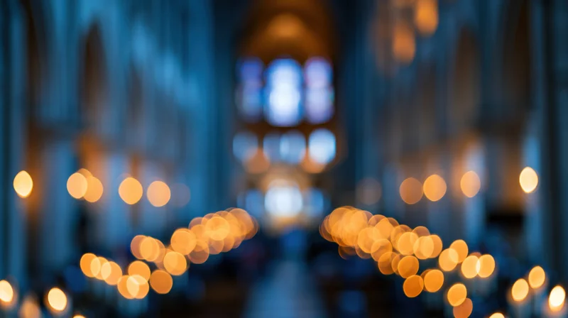 Blurred interior of a cathedral nave with glowing candles and stained glass windows