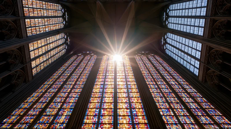 Large gothic stained glass window viewed from below inside a cathedral interior