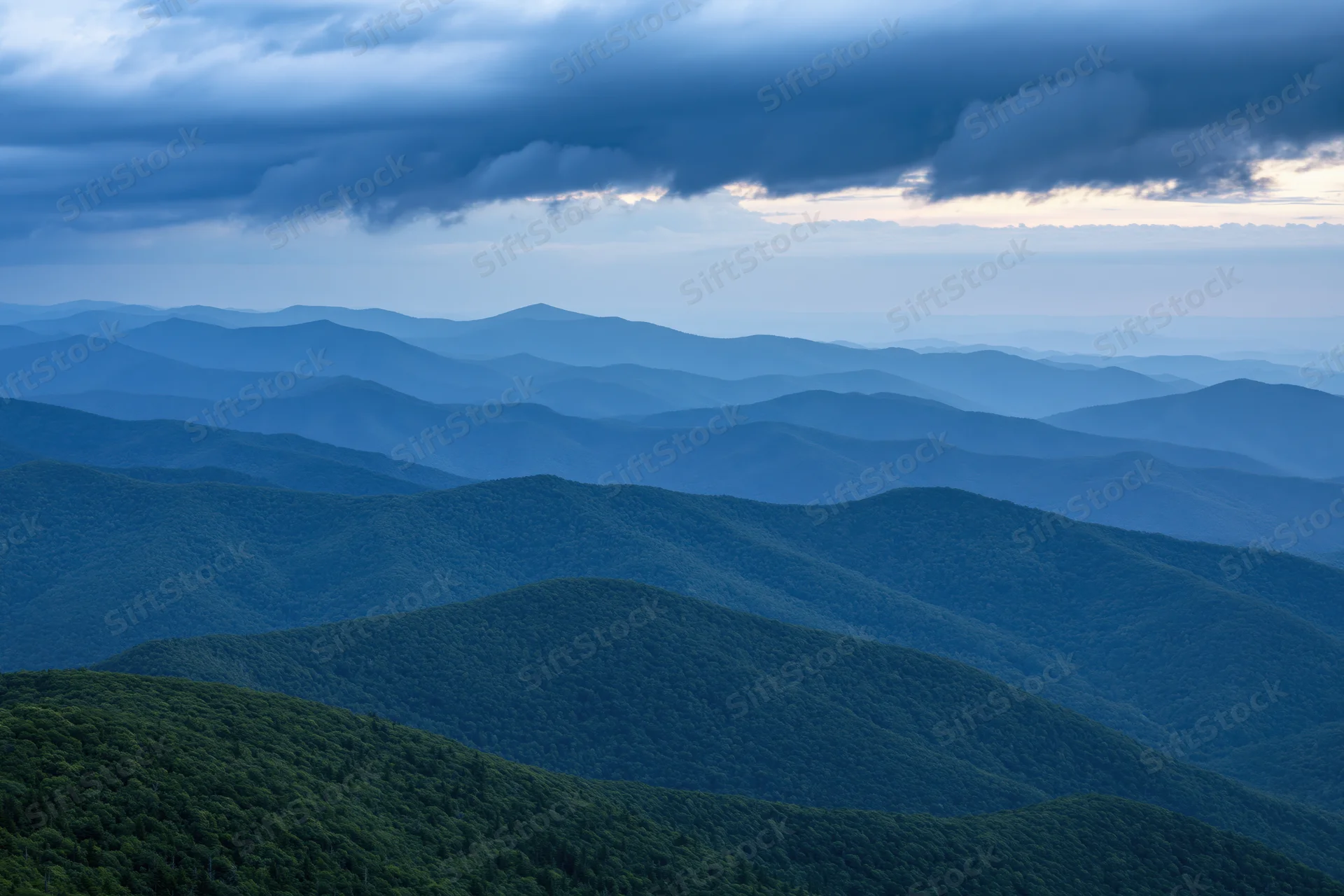 Layered appalachian mountain ridges receding into hazy distance under stormy sky