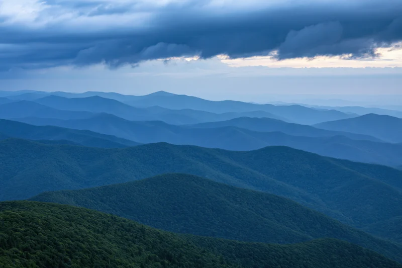 Layered appalachian mountain ridges receding into hazy distance under stormy sky