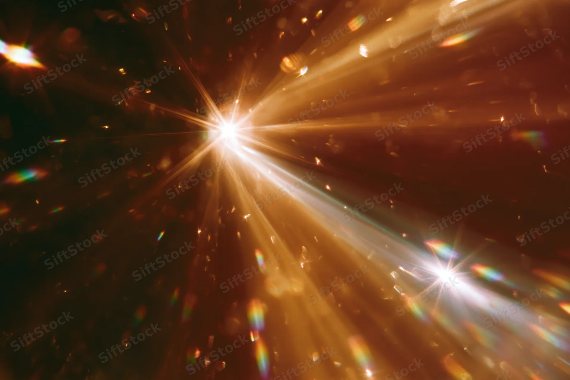 Light refracting through crystal surface creating starburst and rainbow flares in dark background
