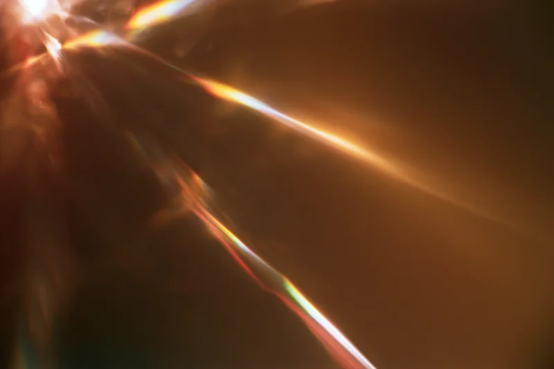 Light refracting through a glass crystal creating a spectrum of colors in closeup view