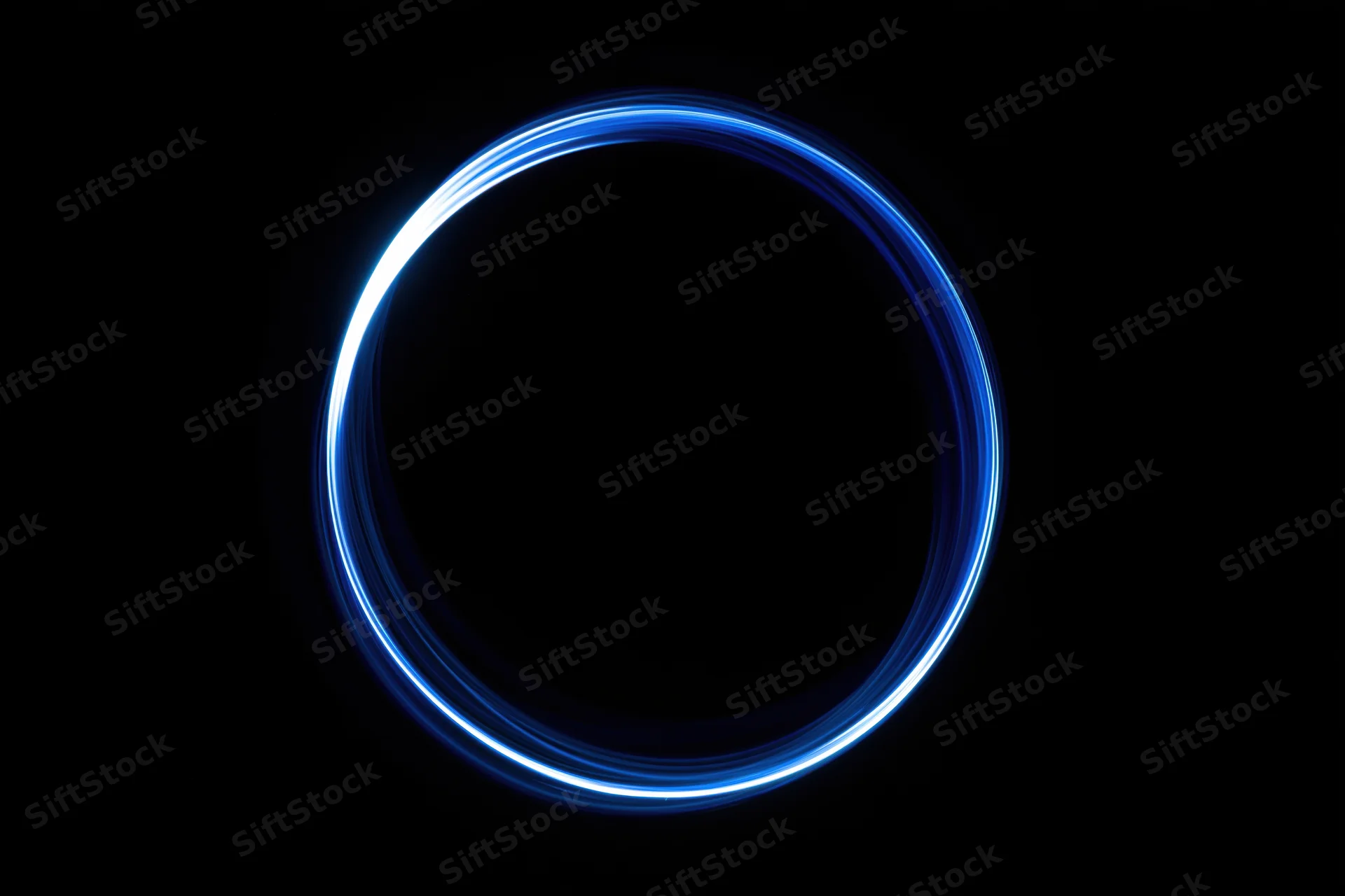 Glowing blue circular light trail against black background from long-exposure light painting photography