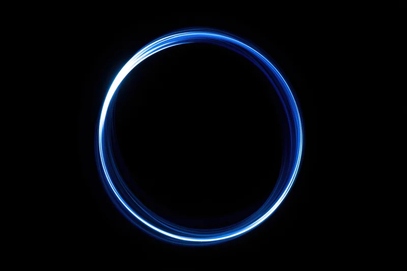 Glowing blue circular light trail against black background from long-exposure light painting photography