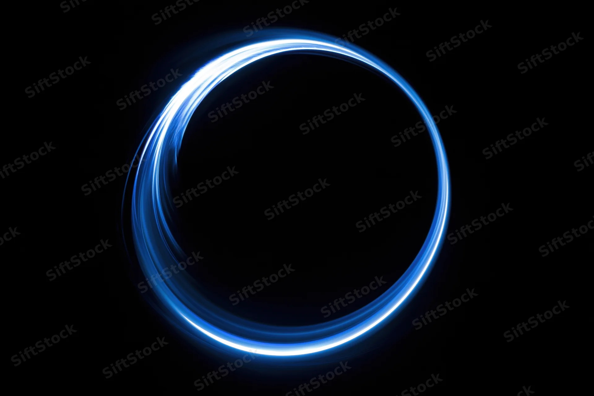 Glowing blue circular light trail in dark space from long-exposure light painting photography