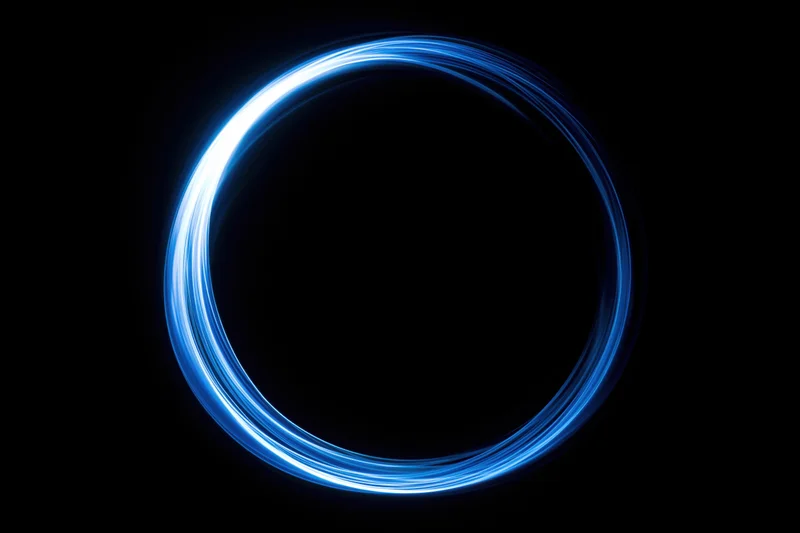 Glowing blue circular light trail formed by long-exposure light painting against a dark background