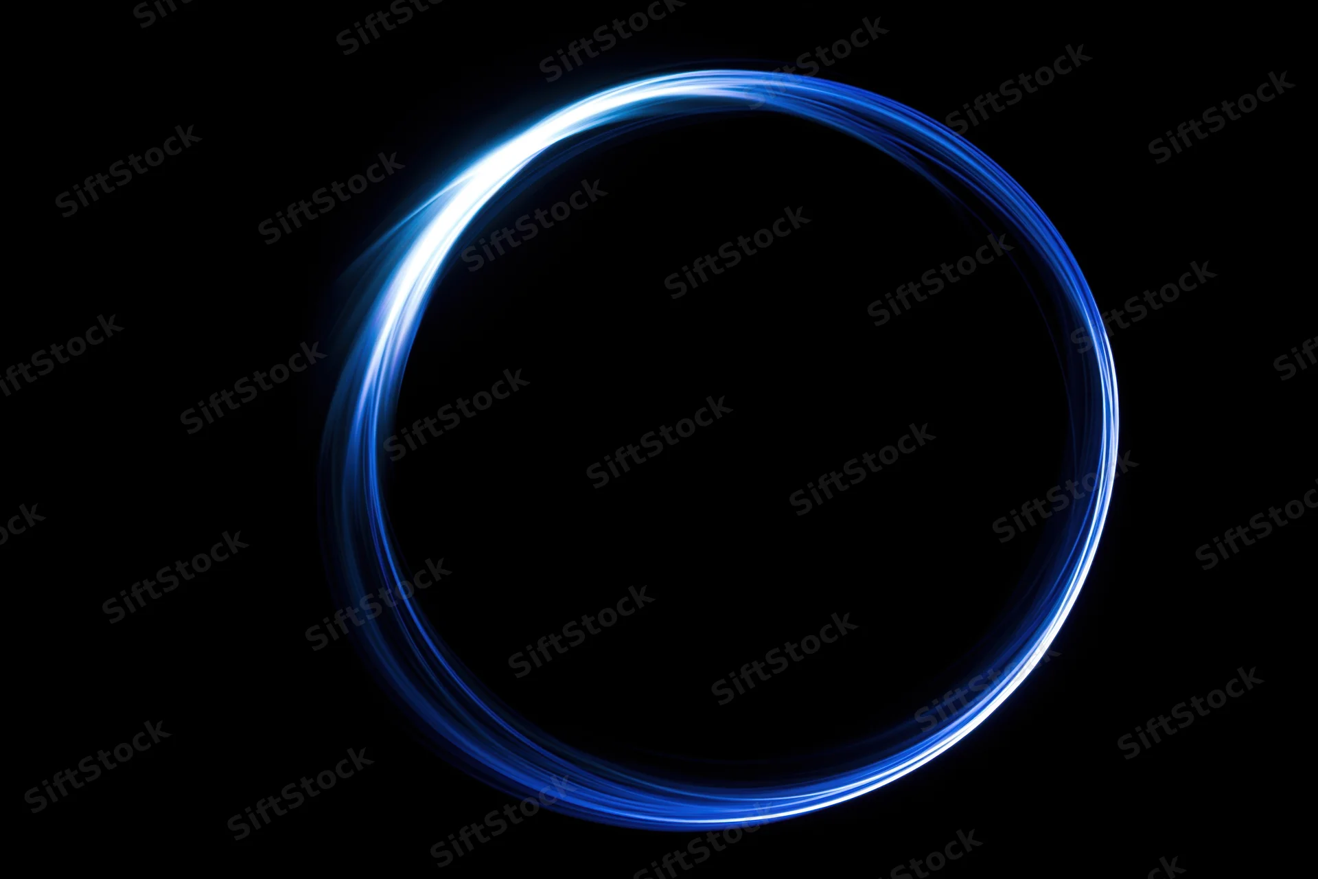 Glowing blue circular light trail on black background with copyspace