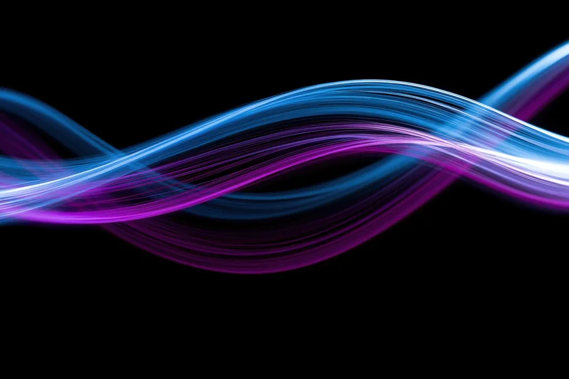 Glowing fiber-optic light waves in motion against black background