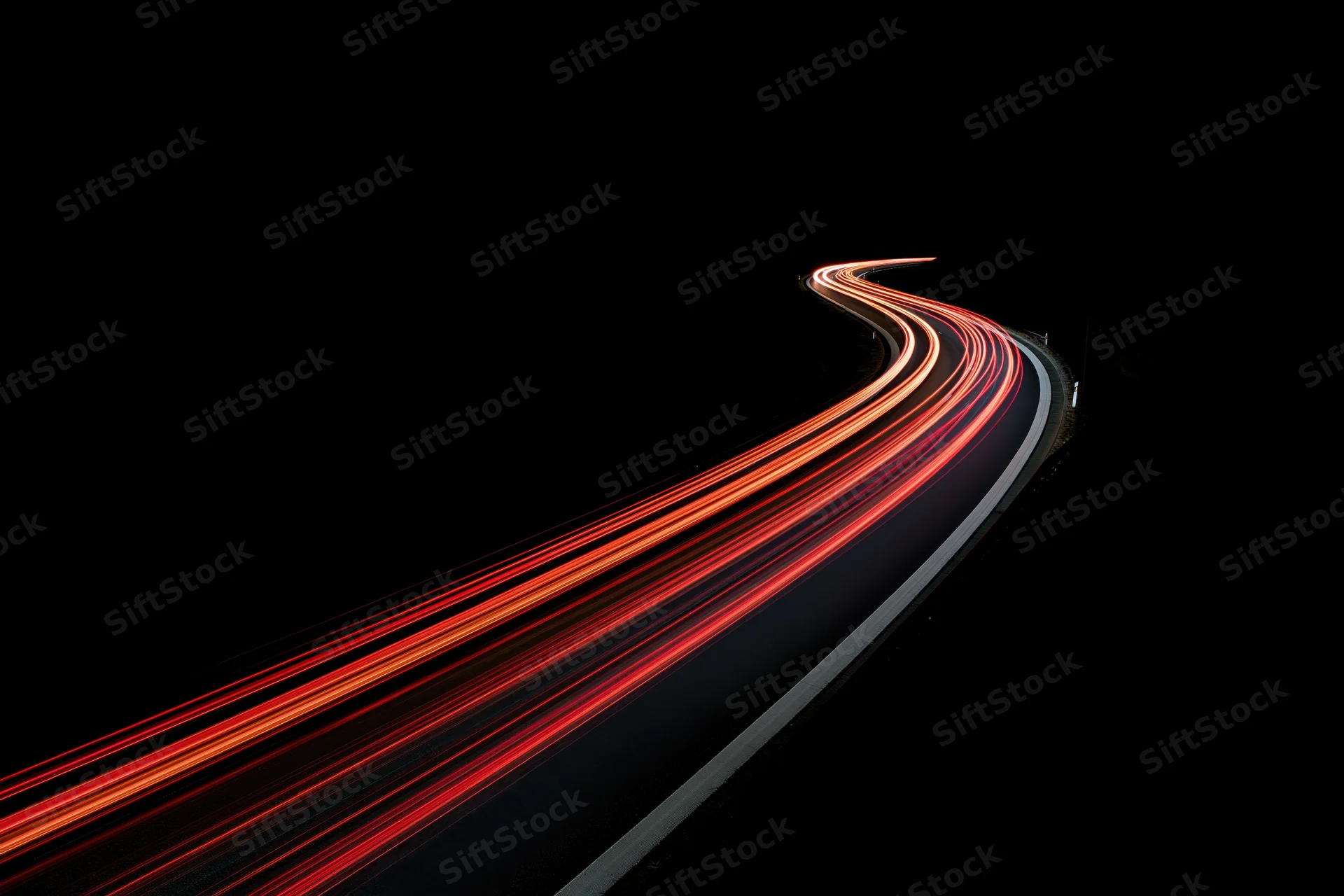 Curving highway at night with red tail light streaks from moving vehicles