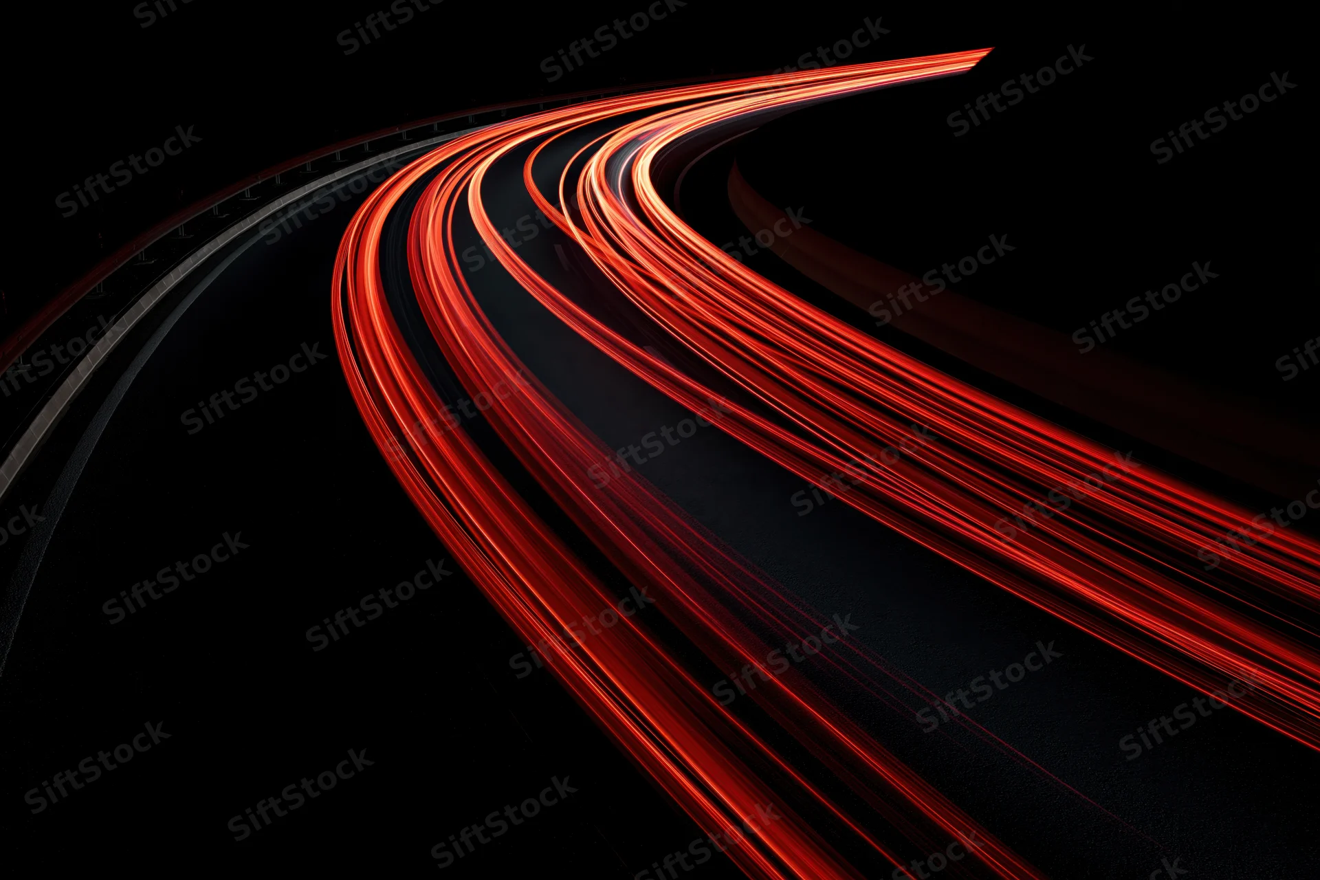 Curving highway at night with red tail light streaks from moving vehicles