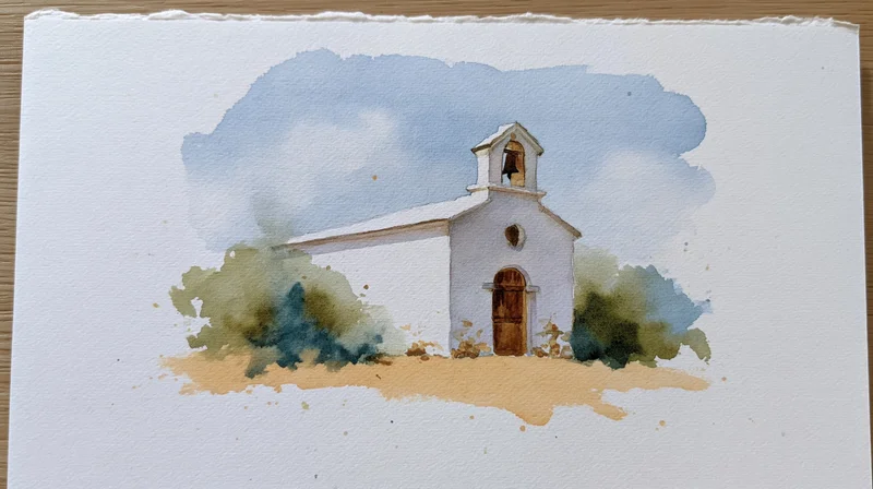 Small white country church with bell tower and green bushes under blue cloudy sky