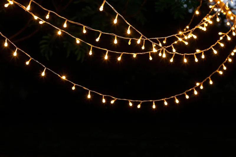 Multiple strands of warm white fairy lights draped loosely outdoors at night