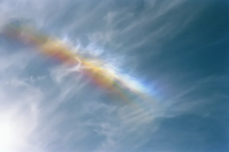 Overexposed sky with wispy cirrus clouds and iridescent lens flare effect
