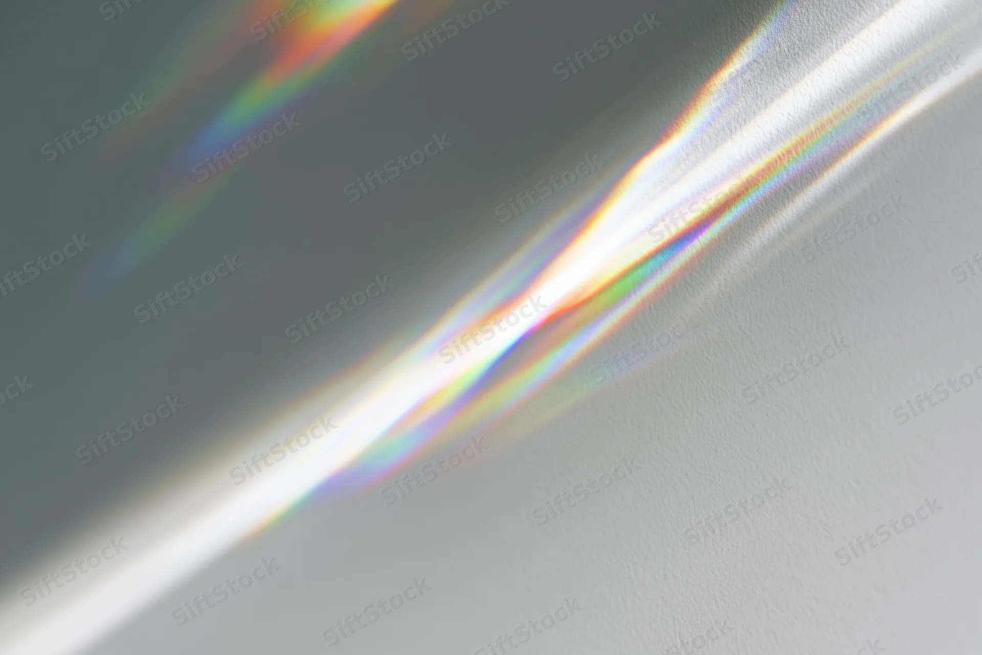 Prismatic light rays refracting across a plain pale grey-white wall