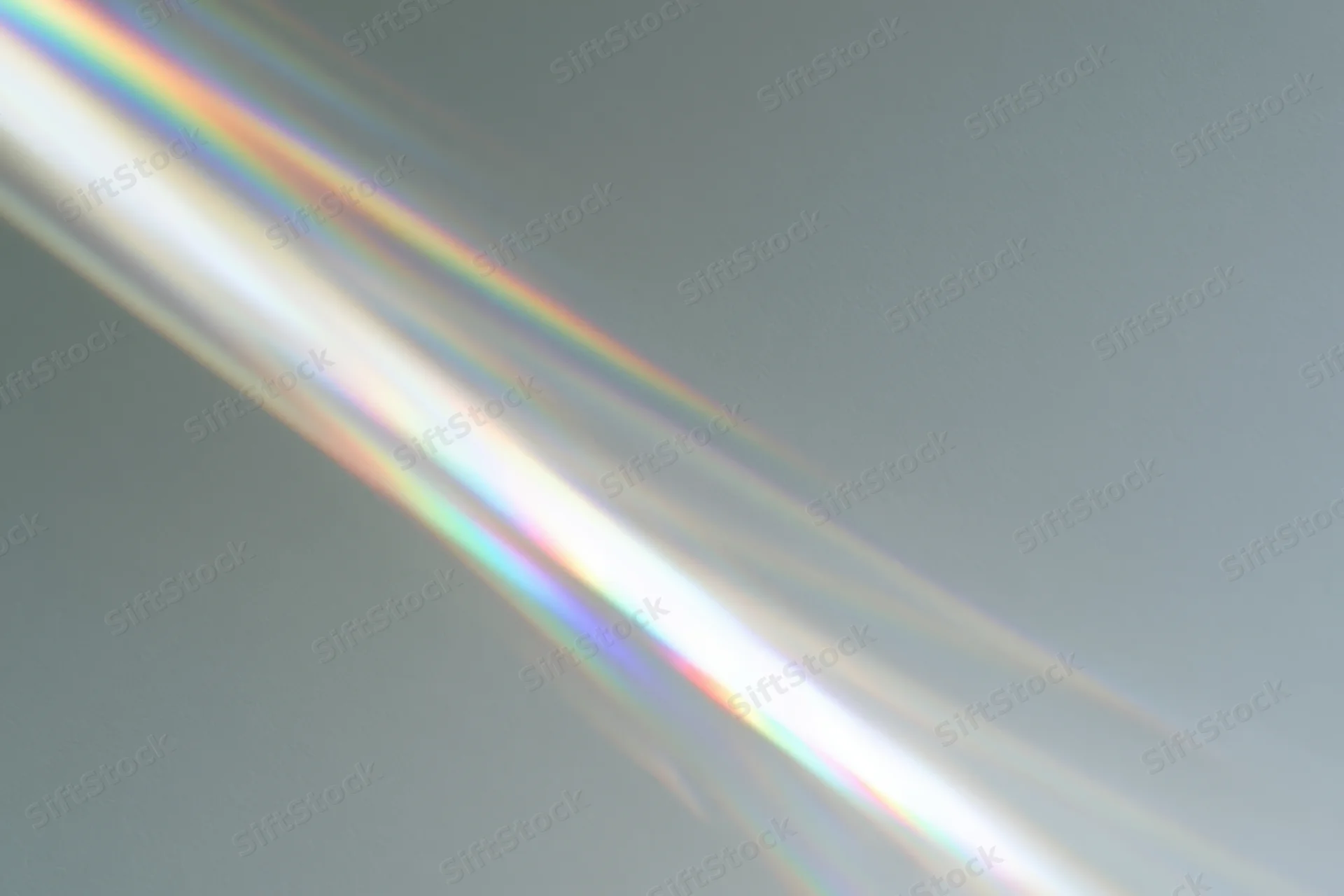 Prismatic light rays refracting across a plain pale grey-white surface