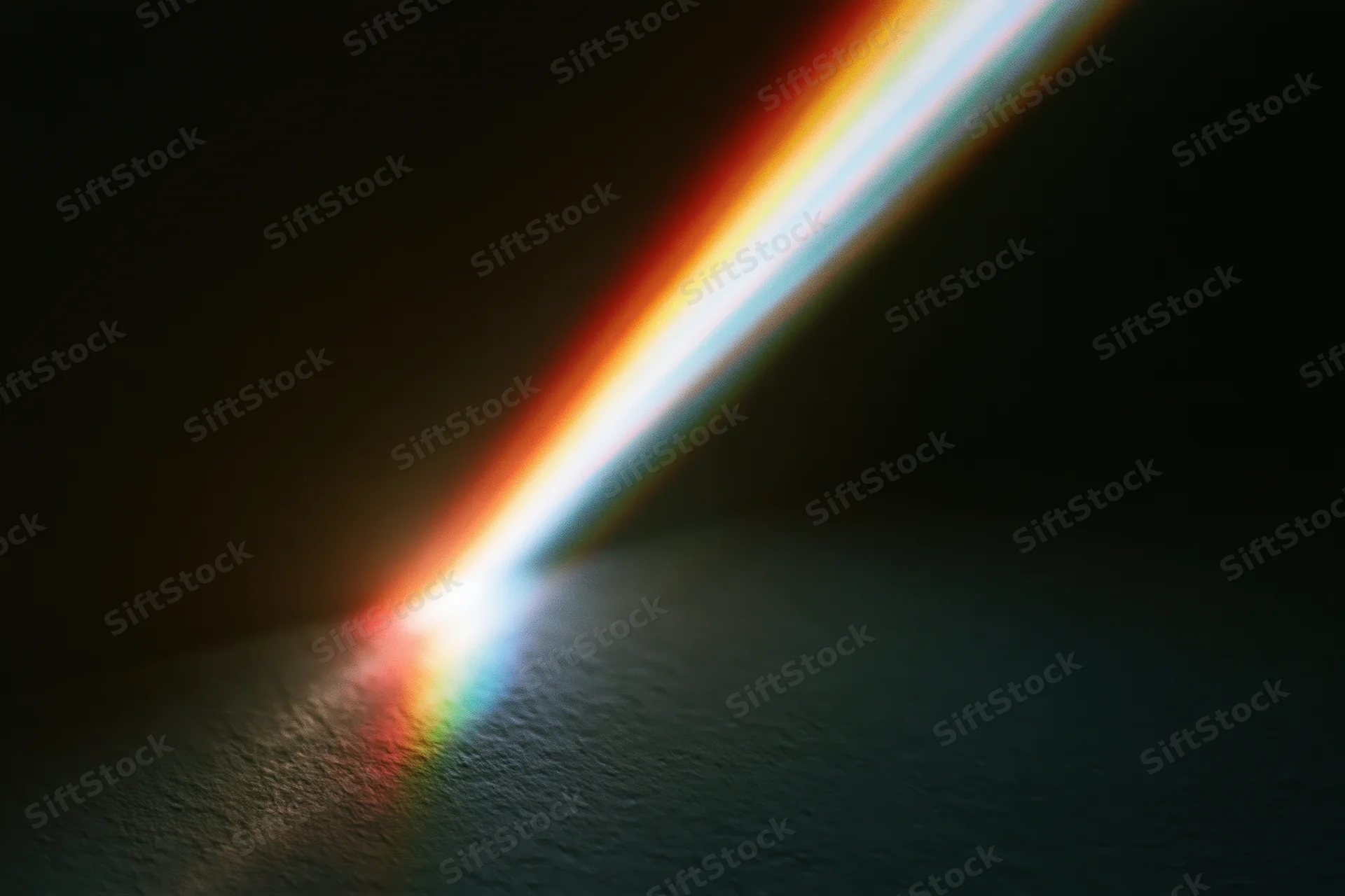 Prismatic light refraction casting a spectrum arc across a dark textured surface