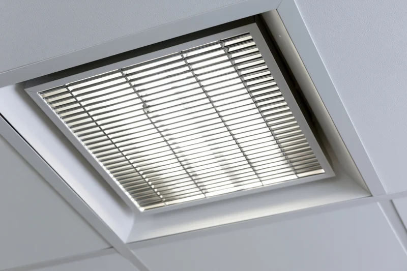 Recessed fluorescent ceiling light fixture in an office drop ceiling grid
