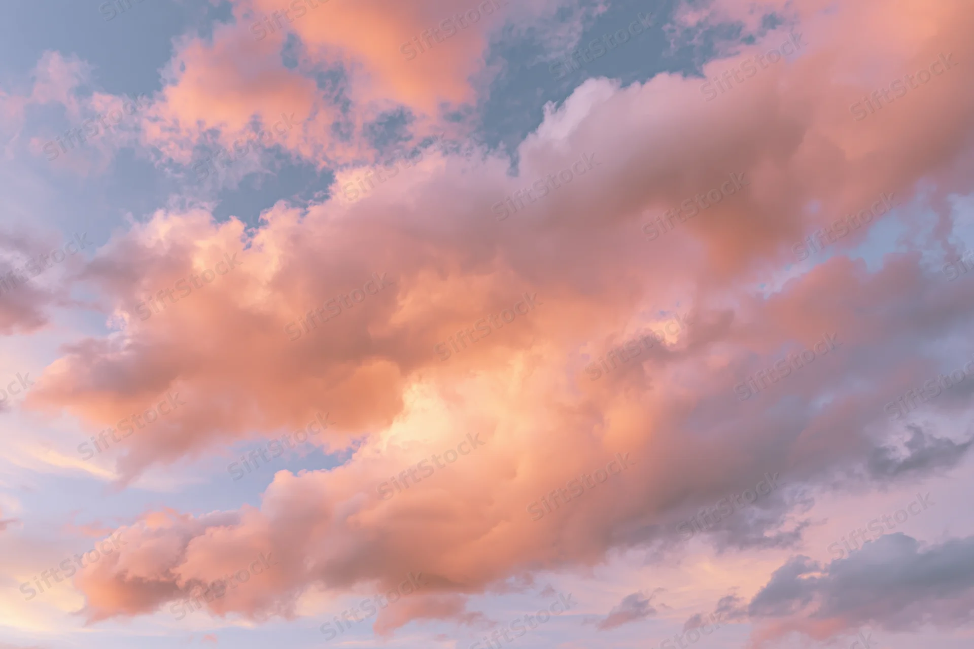 Soft cumulus clouds filling the frame viewed from below at sunset