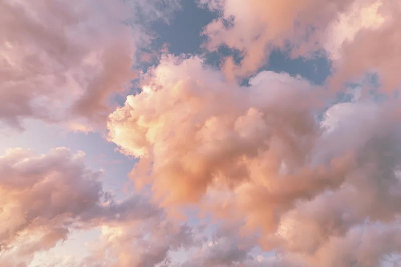 Soft cumulus clouds filling the frame viewed from below against a pastel sky at twilight
