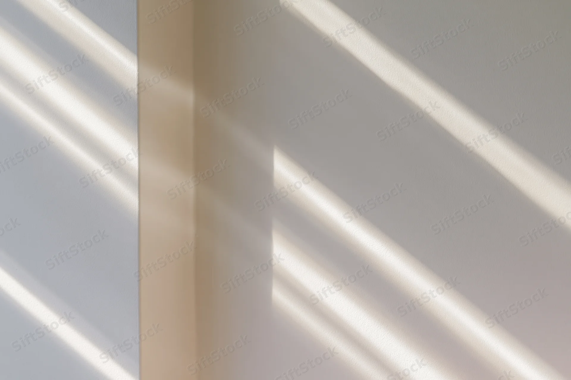 Diagonal window light shadows falling across plain off-white interior walls