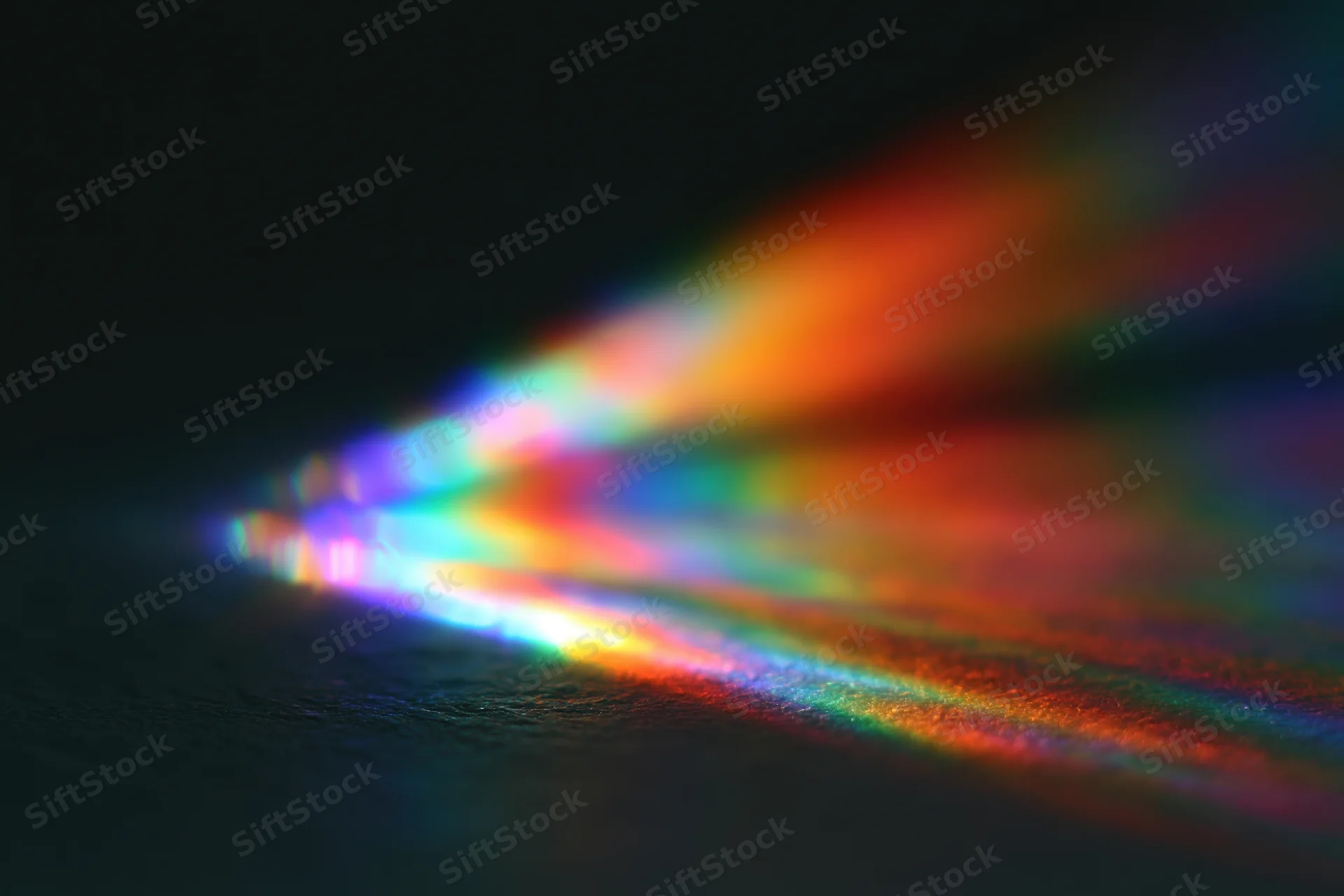 Soft prismatic light diffraction spread across dark surface