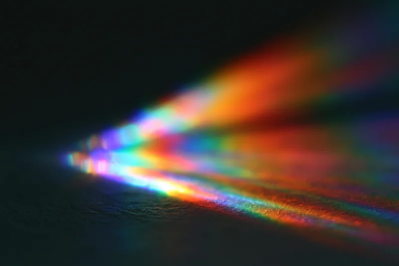 Soft prismatic light diffraction spread across dark surface