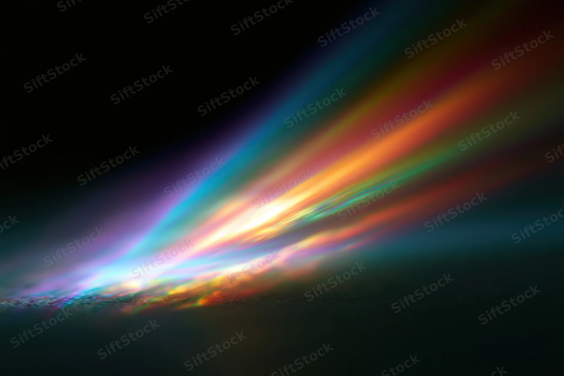 Prismatic light diffraction spreading across a dark surface