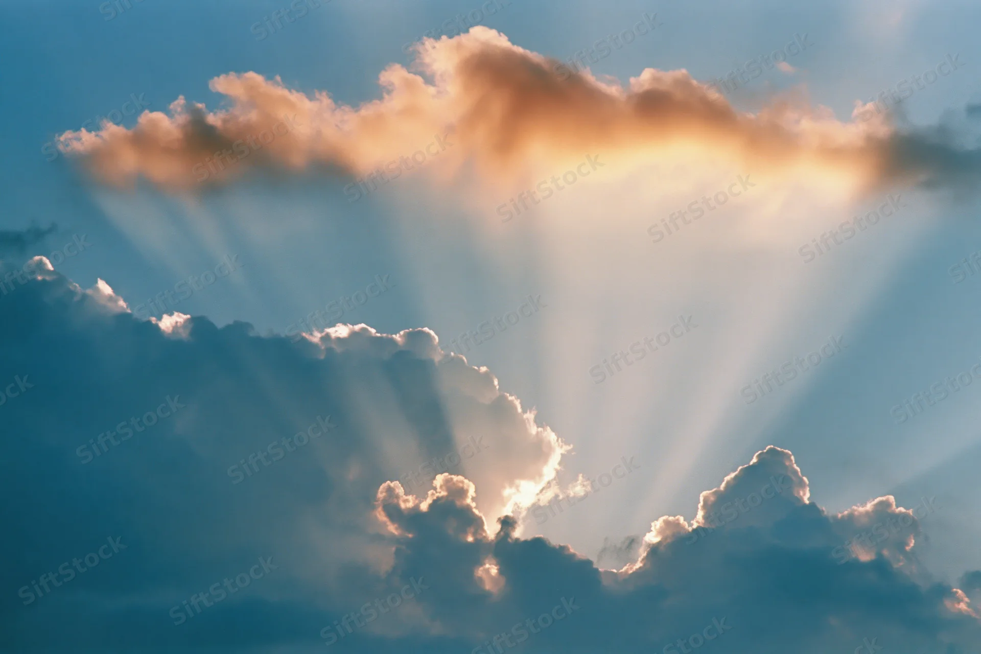 Sun rays breaking through dense clouds in the sky