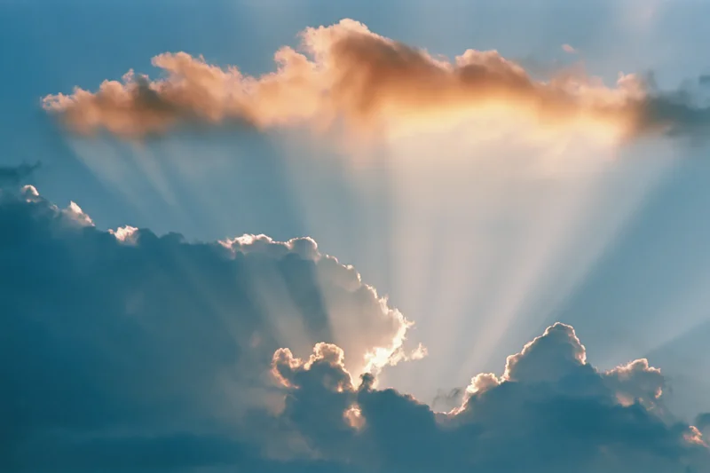 Sun rays breaking through dense clouds in the sky