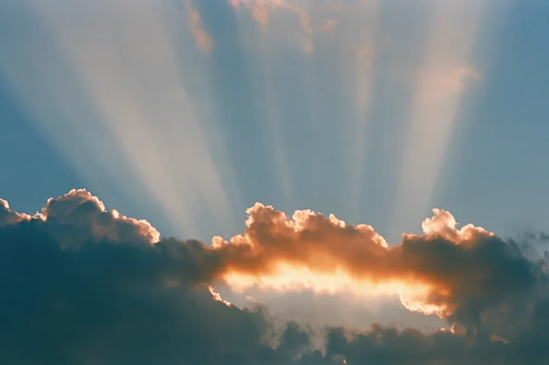 Sun rays breaking through dense cloud bank in sky