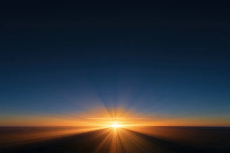 Golden sunrise radiating light rays across the horizon at dawn