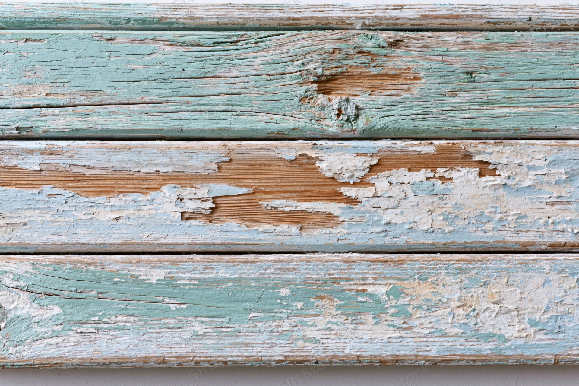 Horizontal weathered wooden planks with peeling paint in teal and white, showing natural wood grain and texture