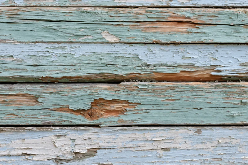 Horizontal weathered wooden planks with peeling paint and exposed grain