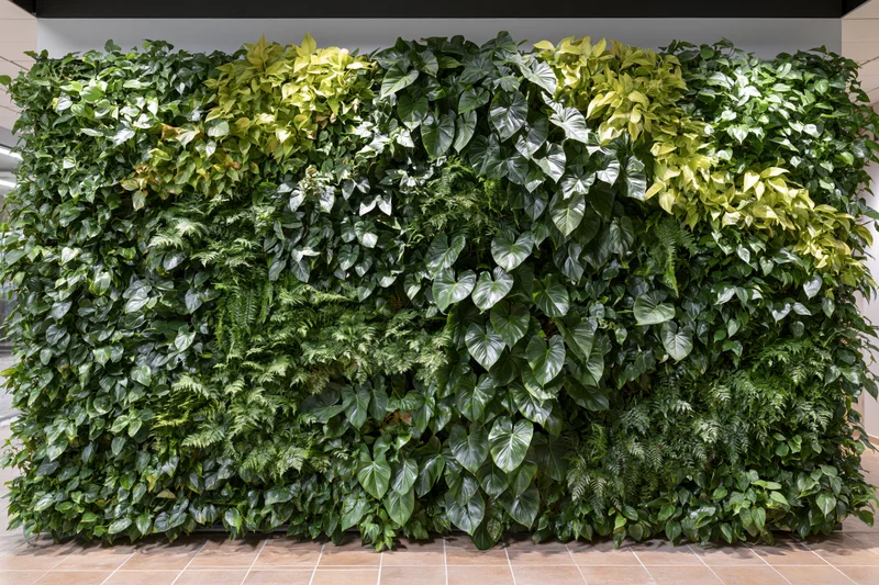 Living green wall installation covering an interior wall with dense foliage and varied plant species