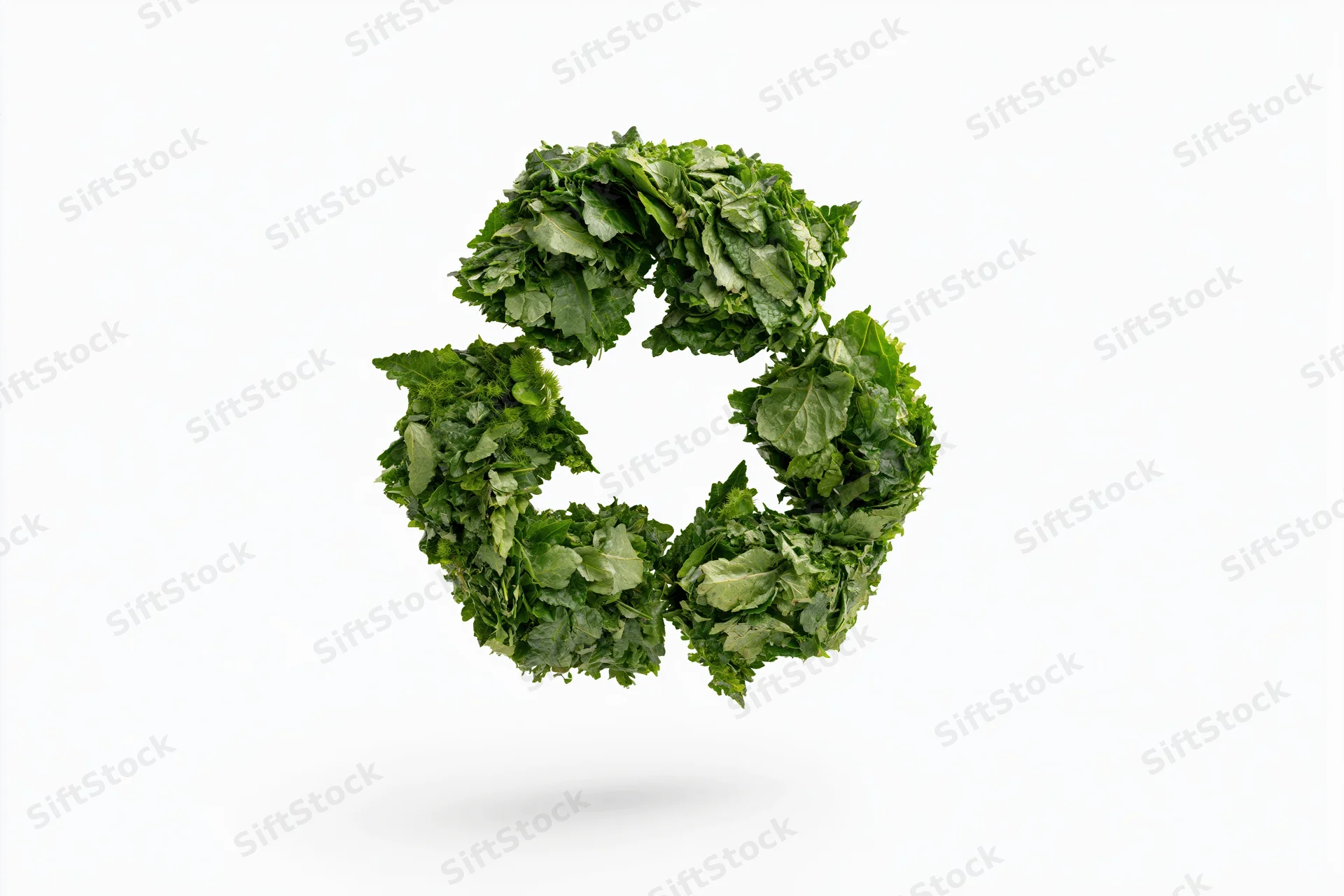Recycling symbol formed from dense green leaves floating against white background