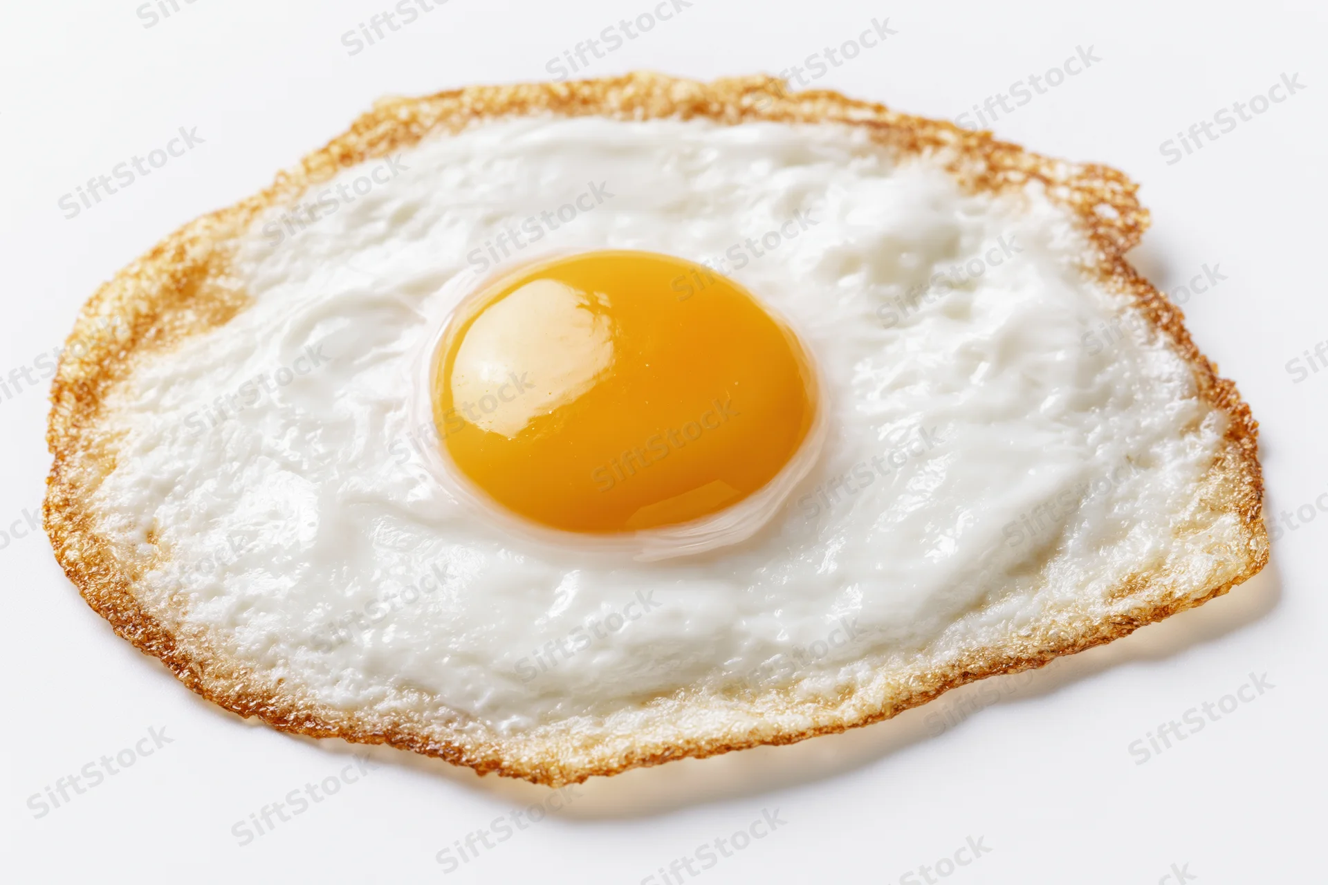 Single fried egg sunny side up with crispy lacy brown edges on white background