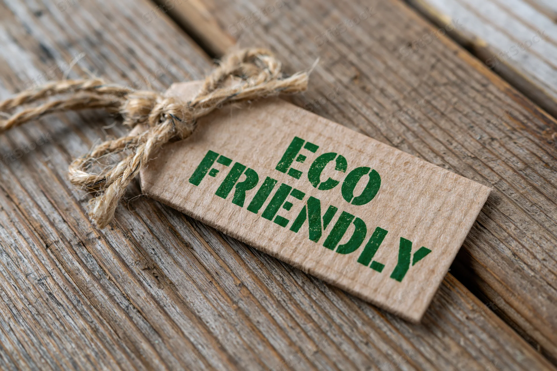 Eco friendly tag made of kraft paper tied with twine resting on a wooden surface