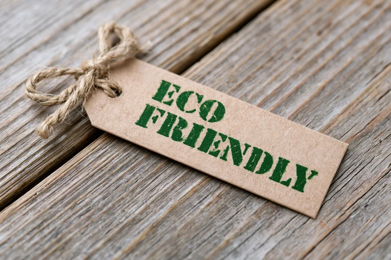 Kraft paper tag with eco friendly text tied with twine on wooden surface