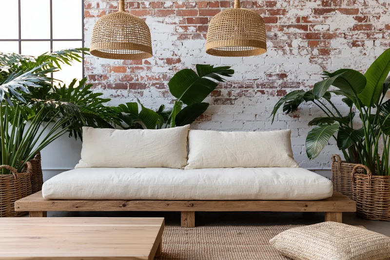Boho living room interior with a wooden linen sofa two cushions