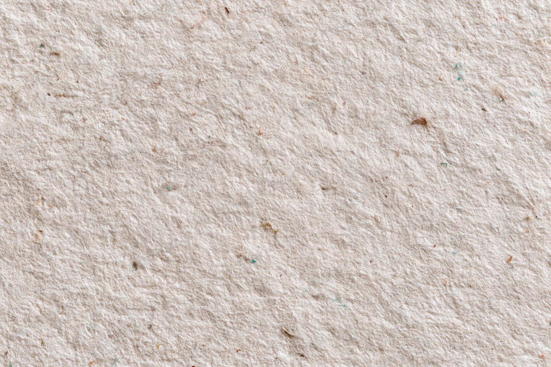 Close-up flat lay of a sheet of recycled kraft paper with visible fibers and texture