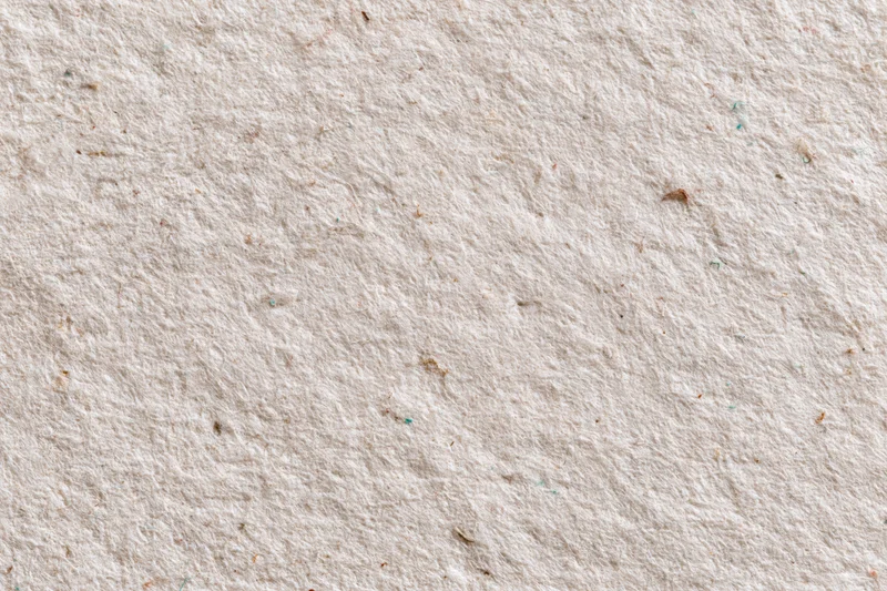 Close-up flat lay of a sheet of recycled kraft paper with visible fibers and texture